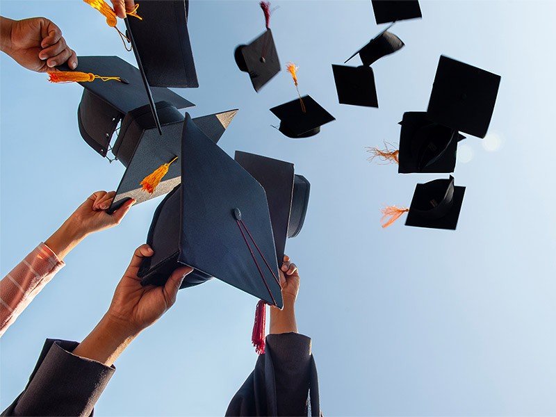 College graduates toss their caps in celebration