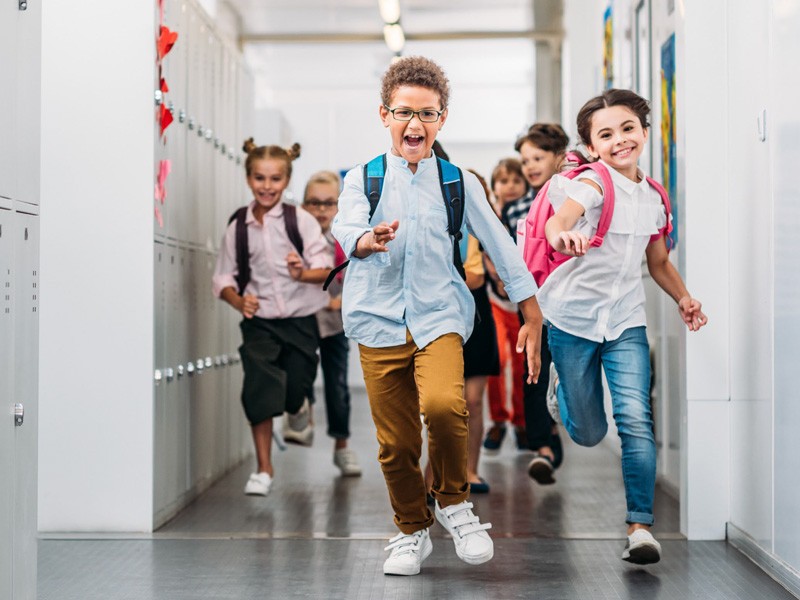 Children running through a school hallway on the first day of school
